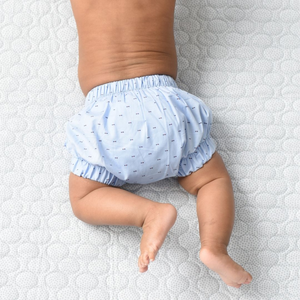 Light Blue baby Knickers featured on baby lying on a quilted blanket for Petits Genoux